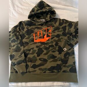 BAPE camo hoodie with orange logo.